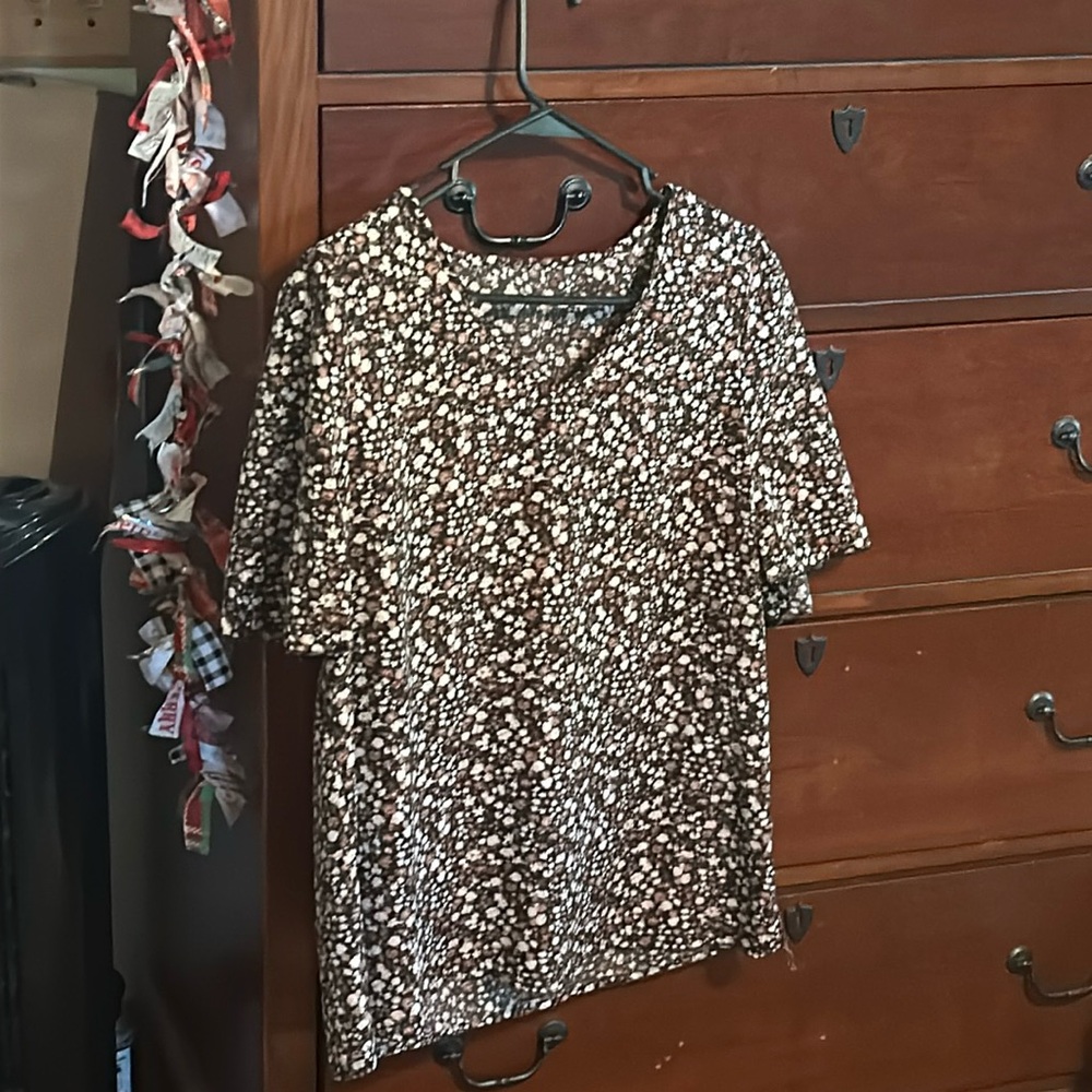 A cute floral top with brown and white flowers with a black base